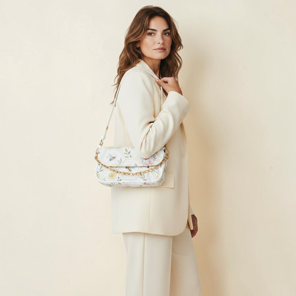 Dreams of Moon white PU leather shoulder bag with floral bee print and gold chain detail, worn by a model.