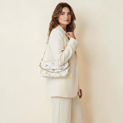 Dreams of Moon white PU leather shoulder bag with floral bee print and gold chain detail, worn by a model.
